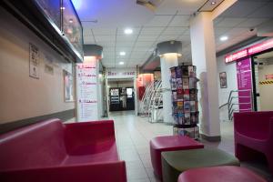 a store aisle with pink chairs and a store at Auberge de Jeunesse HI Paris Le d'Artagnan in Paris
