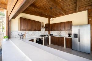 uma cozinha com armários de madeira e electrodomésticos de aço inoxidável em Villa le Fontanelle em Gasperina