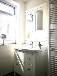 La salle de bains blanche est pourvue d'un lavabo et d'une fenêtre. dans l'établissement Komplettes Ferienhaus für bis zu 4 Personen, à Dornheim