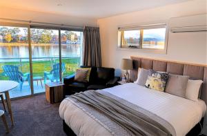 a hotel room with a large bed and a large window at Ulverstone River Edge HolidayApartments in Ulverstone