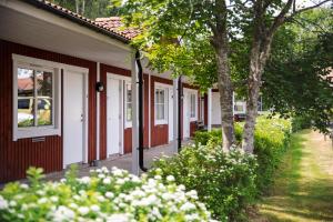 a row of houses with white doors and trees at Hotell Miskarp in Mjölby