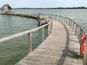 a wooden pier with a boat on the water at Moin ! in Timmendorfer Strand