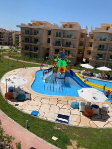 a large swimming pool with a playground in front of a building at مارينا دلتا Alpha star in ‘Izbat Abū Sulayman +13 photos
