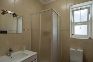 uma casa de banho com um chuveiro, um WC e um lavatório. em Quinta da Cidade em Ponta Delgada
