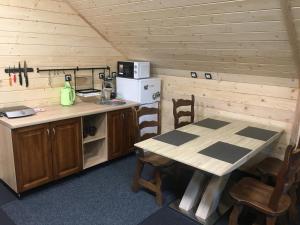 a kitchen with a table and a stove and a refrigerator at Хочу в Карпати in Skole