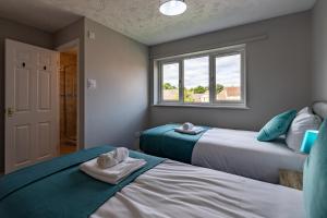 1 dormitorio con 2 camas y ventana en Chandlers House, en Peterborough
