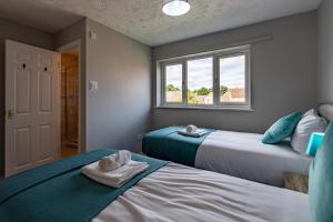 a bedroom with two beds and a window at Chandlers House in Peterborough