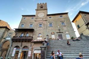 a building with a clock tower on top of it at Sisters’home in Cortona