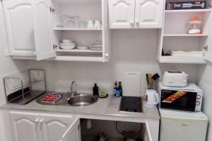 una pequeña cocina con armarios blancos y fregadero en Efigenia playa/mar 2, en Valle Gran Rey