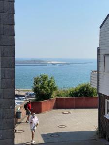 黑尔戈兰岛Hanse Bremerhavener的两个人沿着水边的人行道走