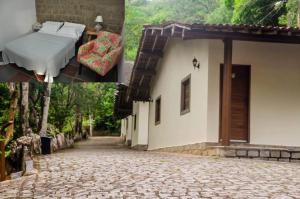 a picture of a bed and a house at Quilombo Hotel Fazenda in União dos Palmares