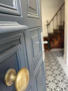 een deur met een gouden deurknop met een trap bij La Villa B in Cholet