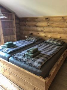 two beds in a room with wooden walls at Lengalm Hütten I & II mit Sauna in Lengdorf