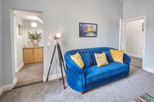 Sofá azul en la sala de estar con cámara en Host & Stay - Riftswood at Ruby en Saltburn-by-the-Sea