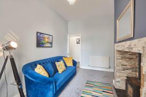 a blue couch in a living room with a fireplace at Host & Stay - Riftswood at Ruby in Saltburn-by-the-Sea