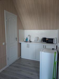 a kitchen with white cabinets and white appliances at Dynastya Inn in Skadovsʼk