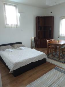 a bedroom with a bed and a table and chairs at Apartman Milica in Kremna