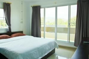 a bedroom with a bed and a large window at U Dee Room and Coffee in Kanchanaburi City