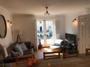 a living room with a couch and a television at The Beach House in Eastbourne