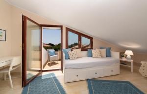 1 dormitorio con 1 cama, escritorio y ventanas en relaxing holiday in Sardinia - Matafaluga apartment, en Capitana