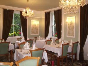 a dining room with white tables and chairs and a chandelier at Rydal Lodge in Rydal