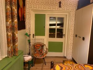 a bedroom with green and white walls and a door at Retro-huisje GoedFout in Olst