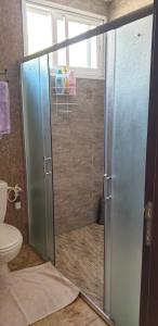 a shower with a glass door in a bathroom at Martini Dead Sea in Neve Zohar