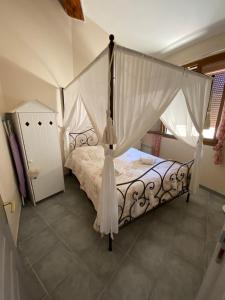 1 dormitorio con cama con dosel y cortinas blancas en Appartement cosy Sérignan en Sérignan