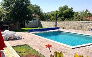a swimming pool in a yard next to a house at Holiday Home Endi in Unešić