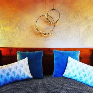 オーヴェル・シュル・オワーズにあるLe Panoramiqueの青い枕2つと壁が備わる客室です。