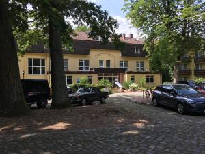 two cars parked in front of a large building at Villa Irene am Inselsee in Mühl Rosin