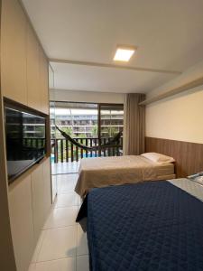 um quarto de hotel com duas camas e uma varanda em Flat no Nannai Residence - Muro Alto - Porto de Galinhas em Porto de Galinhas