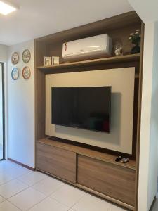 uma sala de estar com uma televisão de ecrã plano na parede em Flat no Nannai Residence - Muro Alto - Porto de Galinhas em Porto de Galinhas