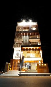 a tall building with a clock on it at night at TRESCA A LUXURY HOTEL in Chikmagalūr