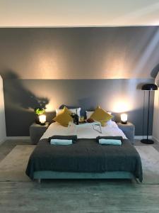 1 dormitorio con 1 cama grande con almohadas amarillas en Pokoje blisko SUNTAGO, en Mszczonów