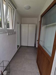 a room with a hallway with a door and windows at Apartma VRTNICA in Bovec