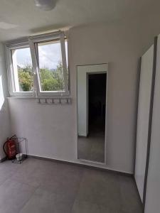 a white room with a mirror and a window at Apartma VRTNICA in Bovec