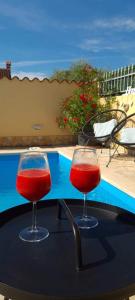 dwa kieliszki wina siedzące na stole obok basenu w obiekcie Holiday Home "Mala kuća " with heated pool w Puli
