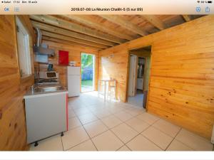a kitchen with wooden walls and a counter top at Chalet rodali in Saint-Pierre