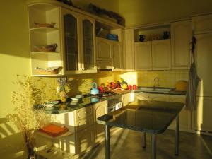 eine Küche mit weißen Schränken und einem Tisch darin in der Unterkunft Prime and Exclusive Seafront Location Apartment Sunset in Trpanj