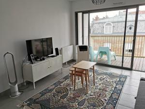 - un salon avec une télévision et une table dans l'établissement Appartement Forum Reims, à Reims