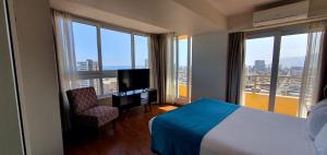 um quarto de hotel com uma cama e uma televisão em Gran Cavancha Hotel & Apartment em Iquique