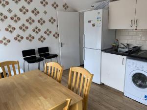 a kitchen with a table and chairs and a refrigerator at Stylish Dublin Apartments in Dublin