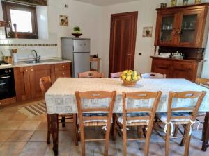 a kitchen with a table with chairs and fruit on it at LA DOLCE VITA in Clastra
