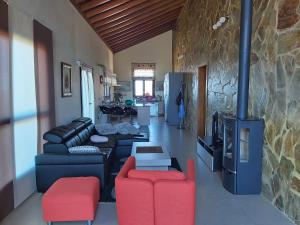 un salon avec un canapé et des chaises rouges dans l'établissement Casa El Peral, à Puntagorda