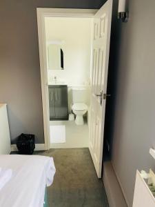 a white bathroom with a toilet and a sink at The Traxx Hotel in Bangor
