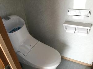 La salle de bains est pourvue de toilettes blanches. dans l'établissement 民泊大森, à Iyo