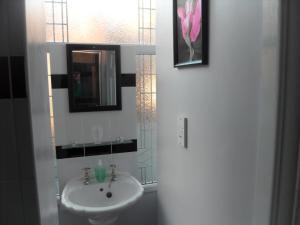 a bathroom with a sink, mirror, and toilet at Bradleys Hotel in Blackpool