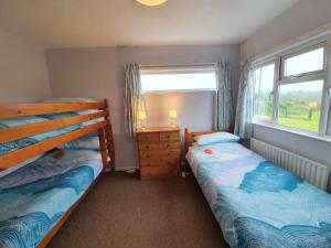 a bedroom with two beds and a window at Ty Pren Bach in Maenclochog