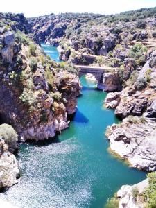 een brug over een rivier in een canyon bij Los Camarotes in Cervera de Buitrago